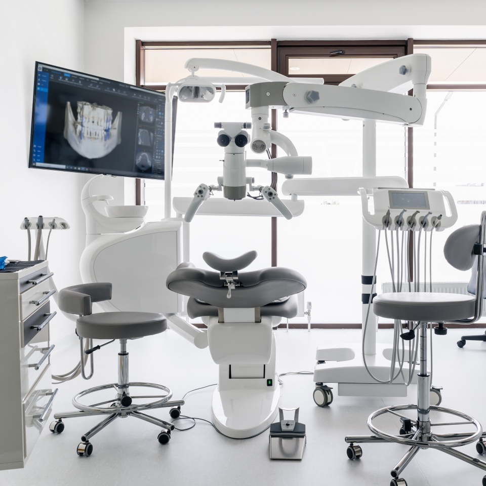 Interior of dental practice room with chair, lamp, display and stomatological tools