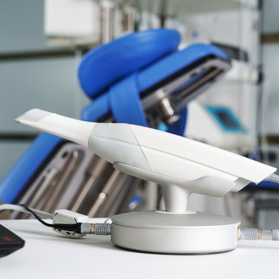 modern intraoral dental scanner connected to a laptop on the background of dental surgery